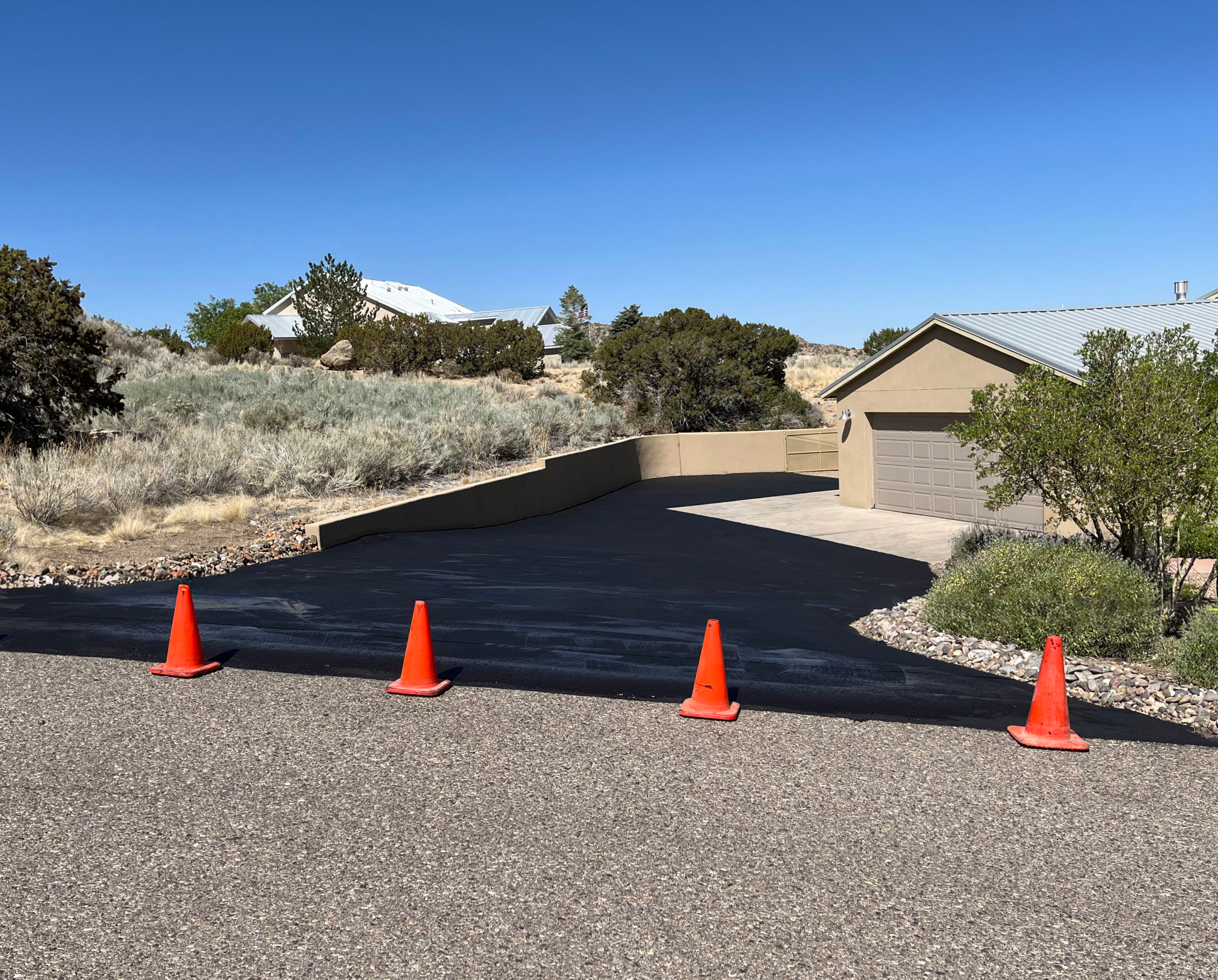 A private driveway that has been repaired by Pioneer Paving and Grading using an asphalt seal coating to protect the existing pavement.