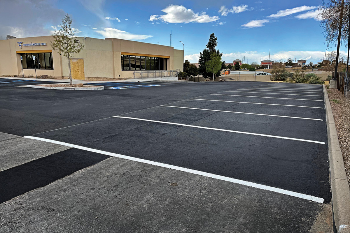 A portion of a parking lot near a doctors office in Albuquerque, New Mexico that has been repaired with an asphalt seal coat, and has had new parking striping done by Pioneer Paving