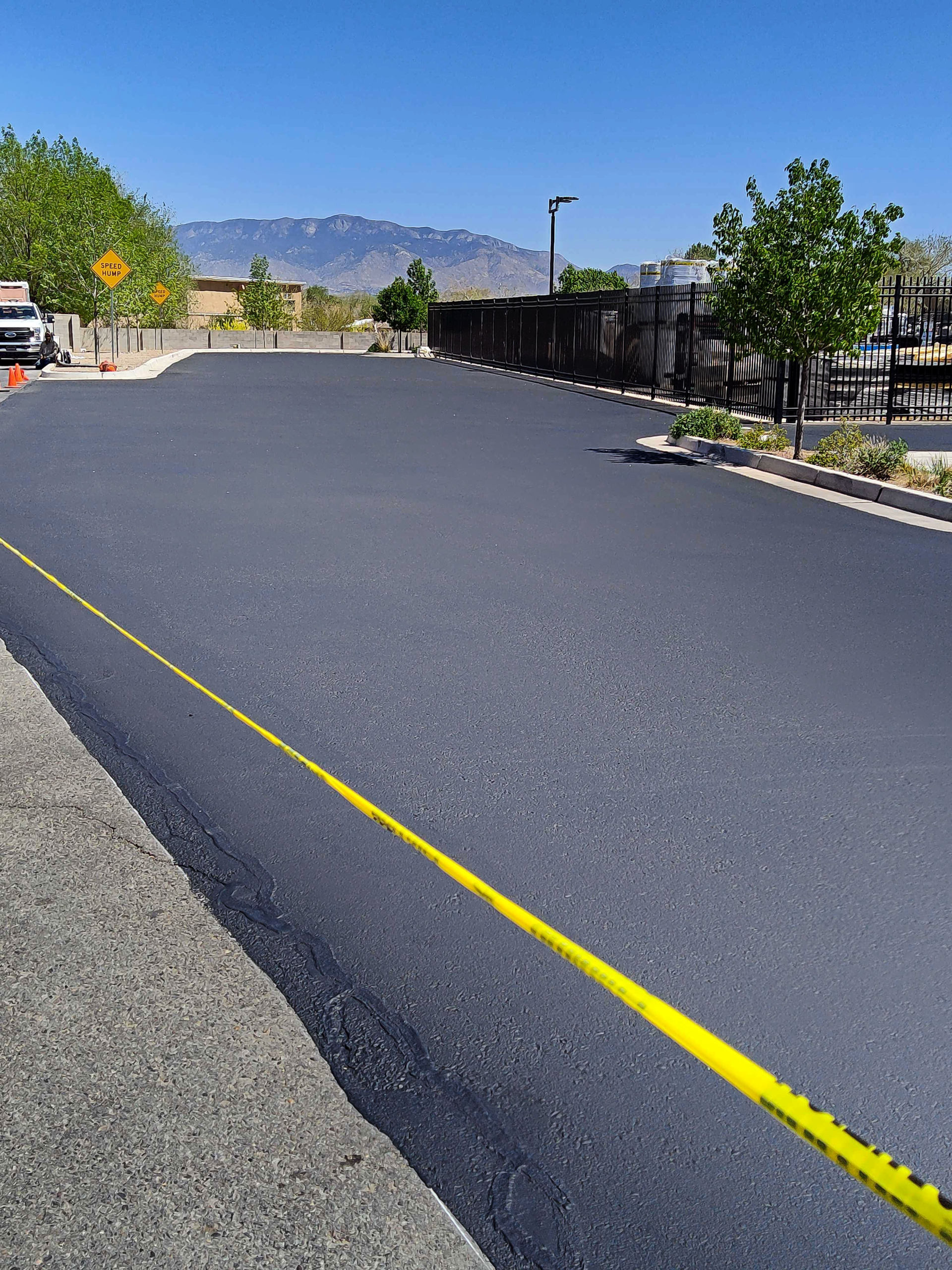 A street that has been repaired with an asphalt seal coat by Pioneer Paving, with the Sandia mountains in the background, in Albuquerque, New Mexico.