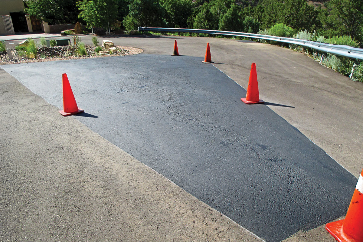 A patched asphalt residential home driveway